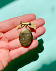 Antique brass bow locket brooch