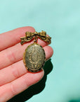 Antique brass bow locket brooch
