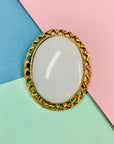 Antique gilt metal costume brooch with white stone