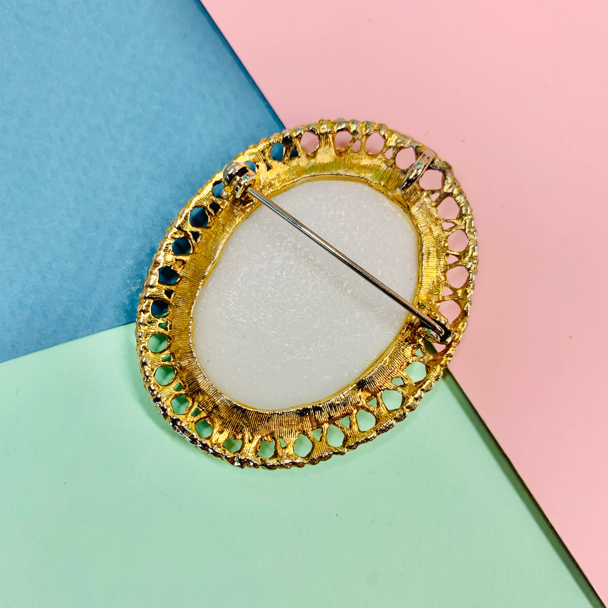 Antique gilt metal costume brooch with white stone