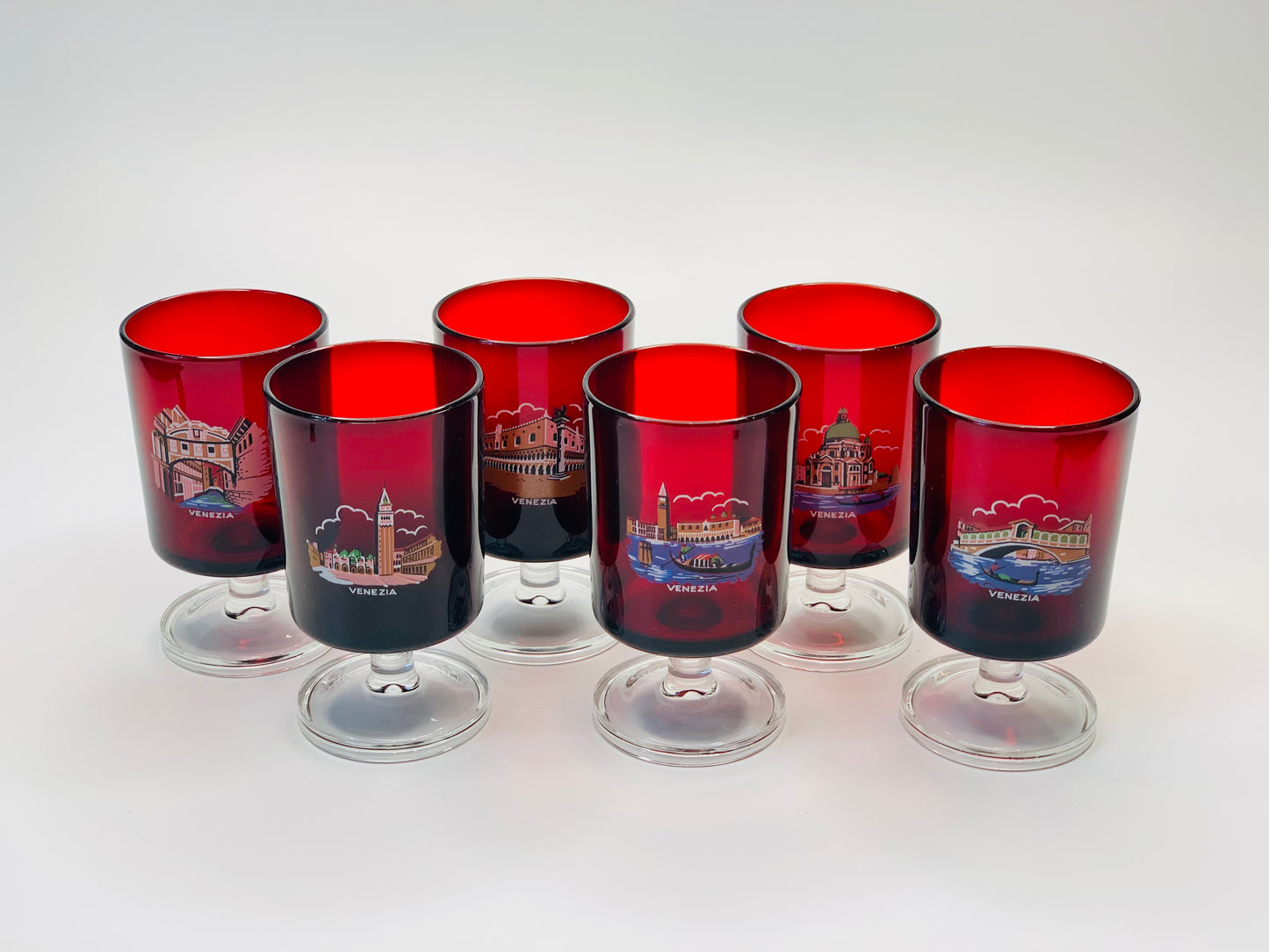 Ruby glass stemware depicting a different famous site of Venice on each glass