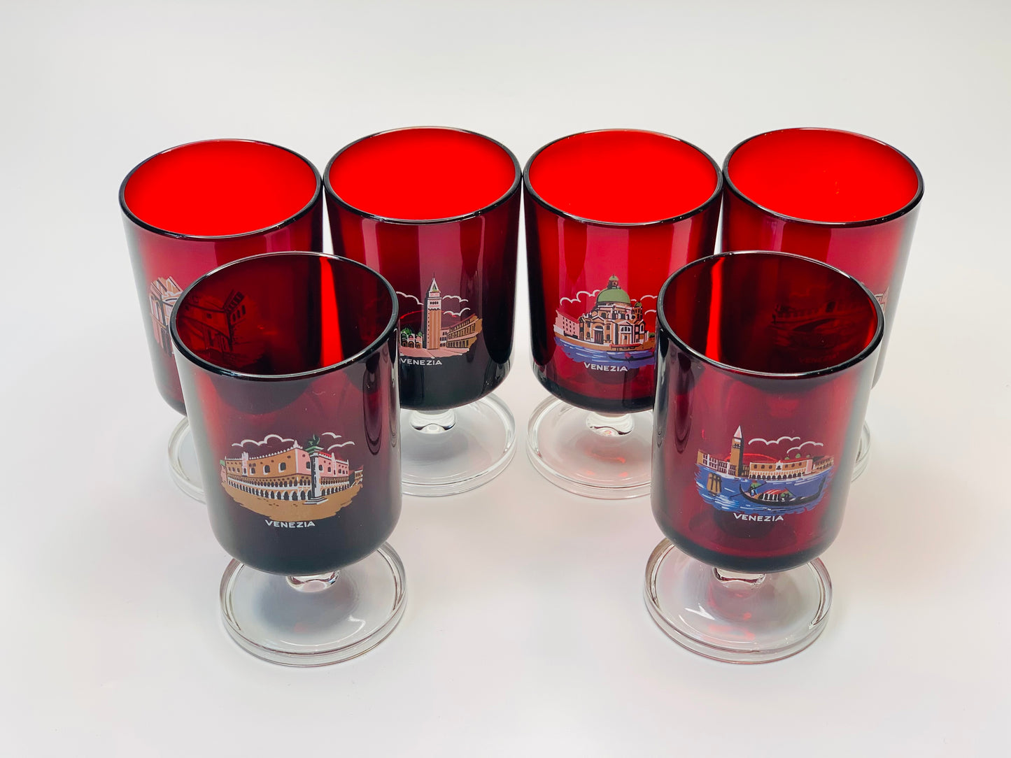 Ruby glass stemware depicting a different famous site of Venice on each glass