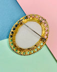Antique gilt metal costume brooch with white stone